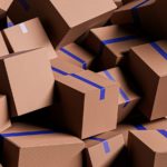 A large pile of brown cardboard boxes with blue tape